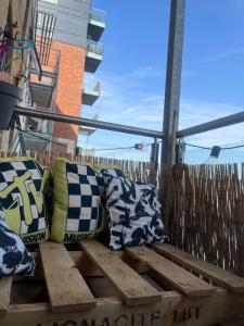 two pillows sitting on top of a wooden bench at THE ONE WITH THE PEACEFUL VIBES in London