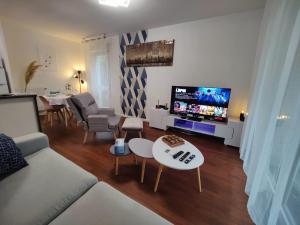 sala de estar con sofá y TV de pantalla plana en QuietStay 20' PARIS, Connected HOME avec Terrasse, en Massy