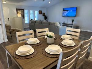 a dining room table with white dishes on top of it at New! Fully Renovated 3/2 Luxury Vacation Home in Venice