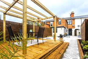 a wooden deck with chairs and a pergola at Boutique luxury Stratford Townhouse- beautifully renovated sleeps upto 4 - free parking - minutes walk to theatres, town & pubs in Stratford-upon-Avon