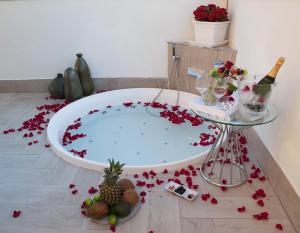 羅馬的住宿－馬爾科安東尼奧豪華套房旅館，地板上装满红色鲜花的浴缸
