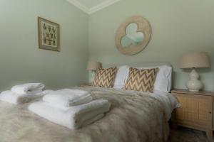 een slaapkamer met een bed met witte dekens en kussens bij Boutique luxury Stratford Townhouse- beautifully renovated sleeps upto 4 - free parking - minutes walk to theatres, town & pubs in Stratford-upon-Avon