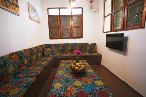 a living room with a couch with a bowl of fruit at Cozy Lodge - Guesthouse in Jambiani
