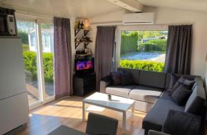 a living room with a couch and a table at Cozy Chalet in Camping 't Venhop in Berkhout