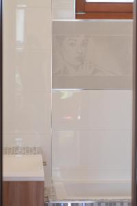 a white kitchen cabinet with a picture of a woman at August Panorama Apartman in Vác