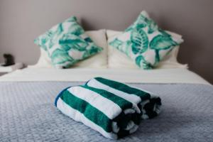 a bed with green and white towels on it at Flora Fauna 84 Aruba Apartment in Palm-Eagle Beach