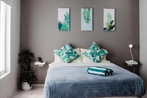 a bedroom with a bed with a blue blanket at Flora Fauna 84 Aruba Apartment in Palm-Eagle Beach