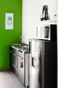 a kitchen with a stainless steel refrigerator and a sink at Flora Fauna 84 Aruba Apartment in Palm-Eagle Beach