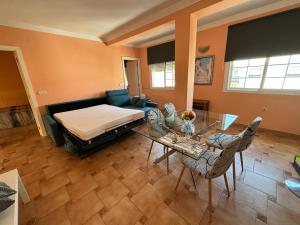 Las Delicias de Estepona في إِستيبونا: غرفة معيشة مع سرير وطاولة وكراسي