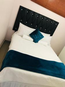 - un grand lit blanc avec un oreiller bleu dans l'établissement Durban Harbour View Apartment, à Durban