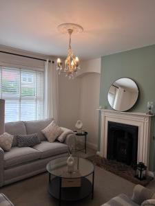 a living room with a couch and a mirror at Victorian Cottage - The Beach Walmer in Walmer