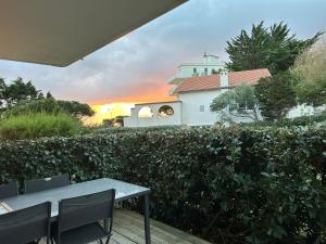 een terras met een tafel en stoelen voor een huis bij LA BAULE : STUDIO MER EN REZ DE JARDIN in La Baule