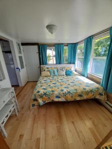 MadisonにあるLemonDrop Lake-Front Cottageのベッドルーム1室(青いカーテン付きの大型ベッド1台付)