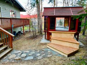 a small cabin with a staircase next to a house at An upscale modern 4 bedroom 2 bath home with Mountain views in Anchorage