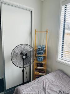 a bedroom with a fan next to a bed at Papamoa B&B in Papamoa