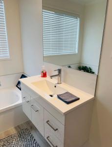 a bathroom with a sink and a mirror at Papamoa B&B in Papamoa