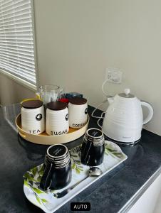 a kitchen counter with a tray of cups and dishes at Papamoa B&B in Papamoa