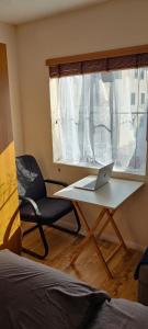 a room with a laptop on a table in front of a window at Wembley house in London