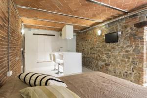 a bedroom with a bed and a brick wall at Loft n°18 in Arezzo