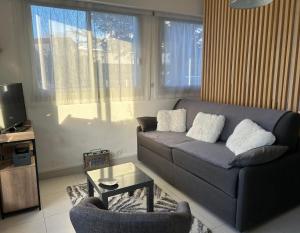 een woonkamer met een bank en een tafel bij LA BAULE : STUDIO MER EN REZ DE JARDIN in La Baule