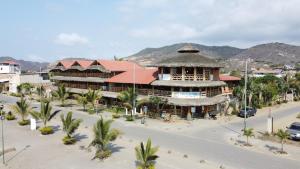 a large building with a red roof on a street at Victor Hugo Hotel in Puerto López