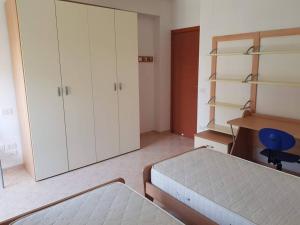 a bedroom with a bed and white cabinets and a chair at Residence Artemide 5° in Isernia