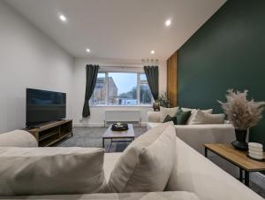 uma sala de estar com um sofá e uma televisão em Oakwood Suite - Sleeps 5 - Contractors - Smart TVs in all rooms em Cheshunt