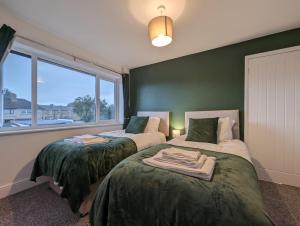 2 Betten in einem Zimmer mit Fenster in der Unterkunft Oakwood Suite - Sleeps 5 - Contractors - Smart TVs in all rooms in Cheshunt