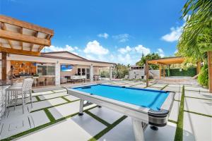 a pool table on the patio of a house at Peaceful Rental Retreat in Miami Jacuzzi, BBQ L25 in Hialeah
