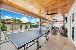 una mesa de ping pong en un patio de una casa en Peaceful Rental Retreat in Miami Jacuzzi, BBQ L25, en Hialeah