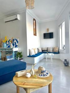 een woonkamer met een blauwe bank en een tafel bij Dar Lahlou in Tanger