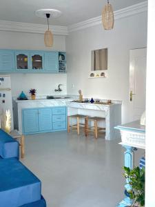 una cucina con mobili blu e tavolo di Dar Lahlou a Tangeri