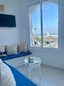 un soggiorno con una grande finestra e un tavolo di Dar Lahlou a Tangeri