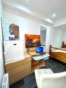 Zimmer mit einem Schreibtisch, einem Laptop und einem Bett in der Unterkunft Beechtree House in Cheshunt