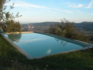 a swimming pool with a view of the mountains at Castello di Mongiovino in Panicale