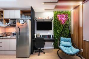 a kitchen with a refrigerator and a chair in a room at Studio Design Próx ao Metrô Brás com piscina in São Paulo