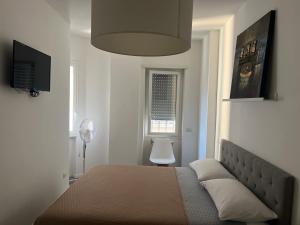 1 dormitorio con cama, lámpara y ventana en Tiburtina FLAM guest house, en Roma