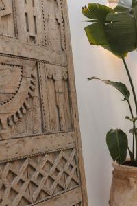 a plant in a vase next to a wooden door at M-17 Riad & Spa in Marrakesh