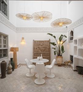 a room with a table and white chairs and a table at M-17 Riad & Spa in Marrakesh