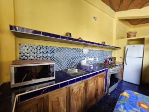 a kitchen with a sink and a microwave at Villa Corona del Mar in Rincon de Guayabitos