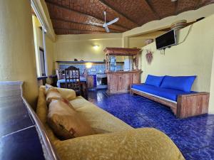a living room with a couch and a tv at Villa Corona del Mar in Rincon de Guayabitos