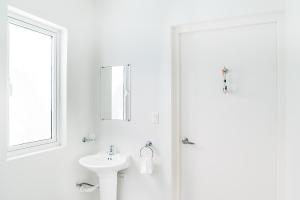 鷹海灘的住宿－Flip Flop Apartment 84，白色的浴室设有水槽和镜子