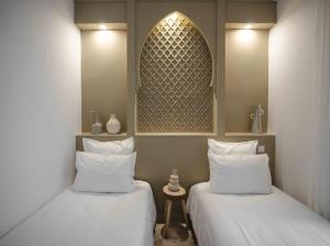- deux lits assis l'un à côté de l'autre dans une pièce dans l'établissement M-17 Riad & Spa, à Marrakech