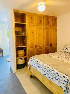 a bedroom with a bed and wooden cabinets at Studio à Proximité de l'Aéroport Las Américas in Boca Chica