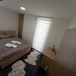 1 dormitorio con cama, ventana y alfombras en Apartment Magic snow, en Kopaonik