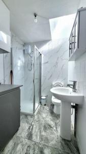 a bathroom with a sink and a shower and a toilet at 'TheFive' Camden Town in London