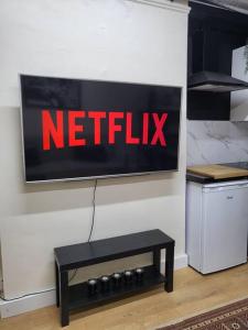 a netflix sign on a wall next to a table at 'TheFive' Camden Town in London