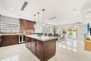 a kitchen with wooden cabinets and a large island at Peaceful Rental Retreat in Miami Jacuzzi, BBQ L25 in Hialeah