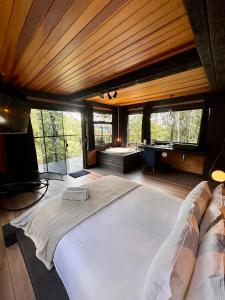 ein Schlafzimmer mit einem großen Bett in einem Zimmer mit Fenstern in der Unterkunft Casa Container 80 in Campos do Jordão