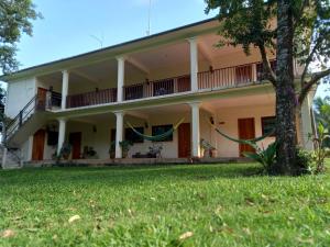 a large white house with a green yard at Hniu Li Valle Nacional in San Juan Bautista Valle Nacional